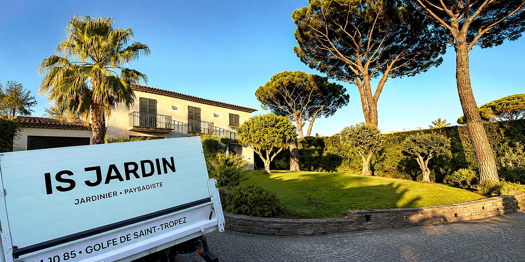 Camion IS JARDIN devant une villa du Golfe de Saint-Tropez, allée bordée de pins parasols